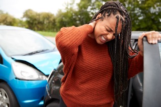 Female Motorist With Whiplash Injury In Car Crash Getting Out Of Vehicle